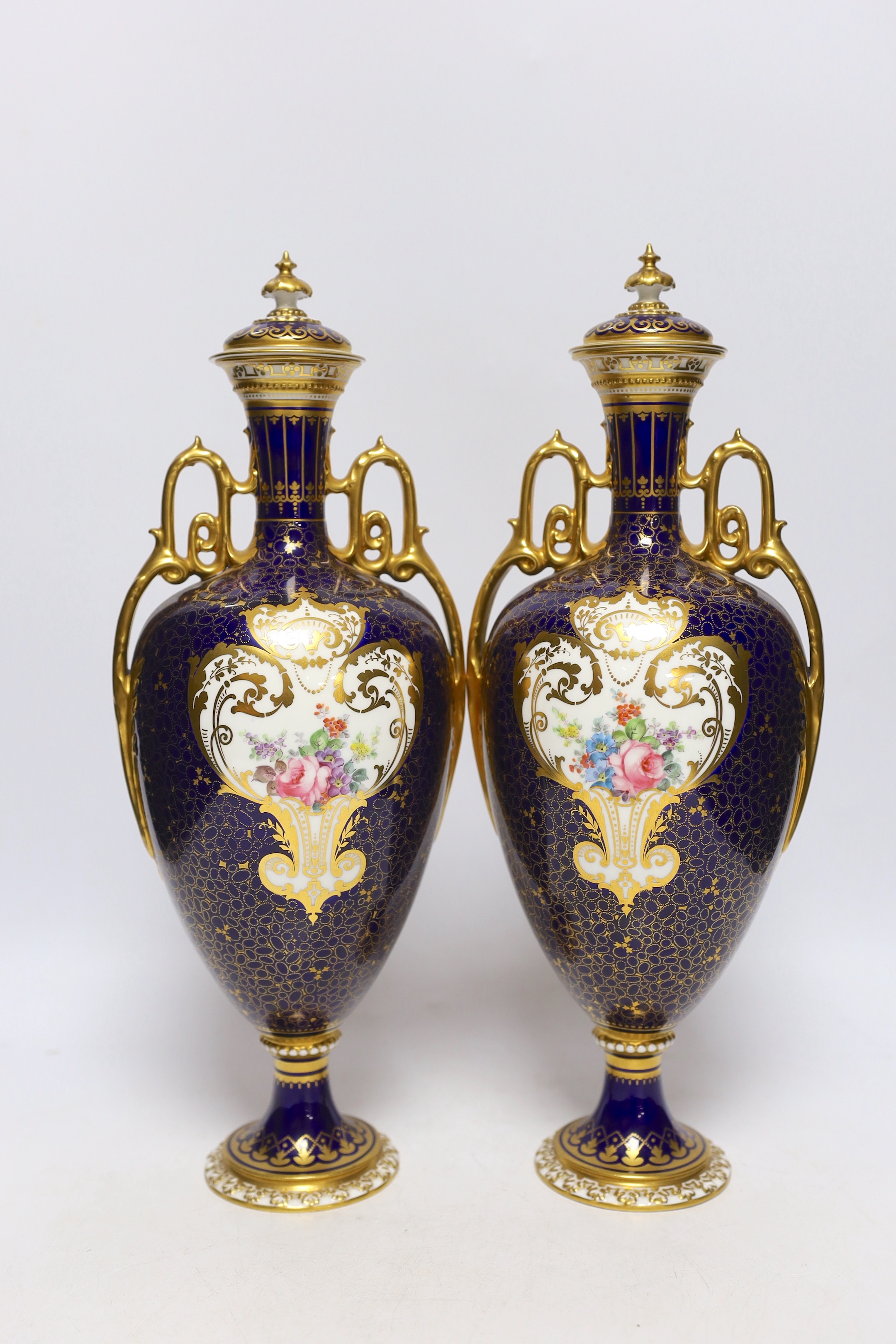 A pair of Royal Crown Derby porcelain urns and covers together with a smaller example and an Imari style jar and cover, 36cm high